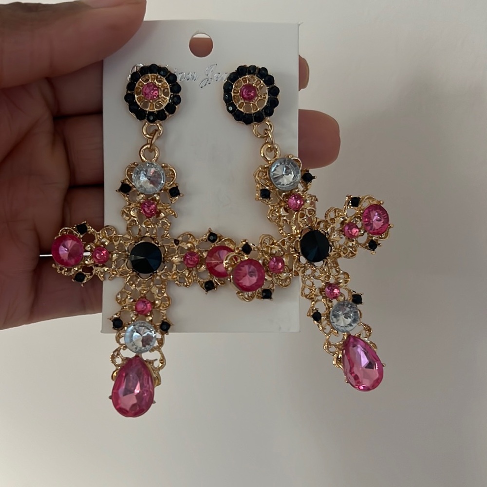 Gold cross earrings with pink and black accents.